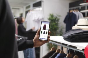 Person browsing AI-personalized clothing recommendations on a mobile shopping app inside a retail store.